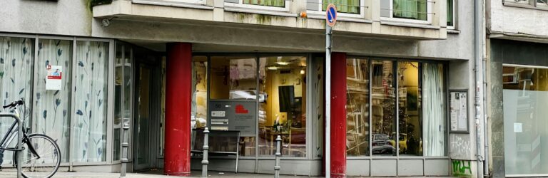 Das Gebäude des SKM Aachen, eine moderne Einrichtung in städtischer Umgebung. Es zeigt einen klaren, funktionalen Eingang und große Fenster.